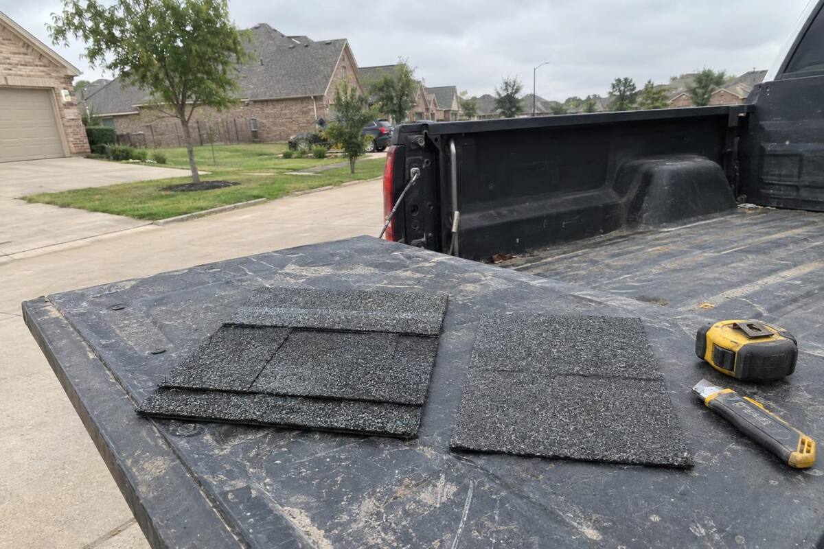 Close-up of a laminated architectural shingle surface next to a thinner flat-profile shingle on a sample board
